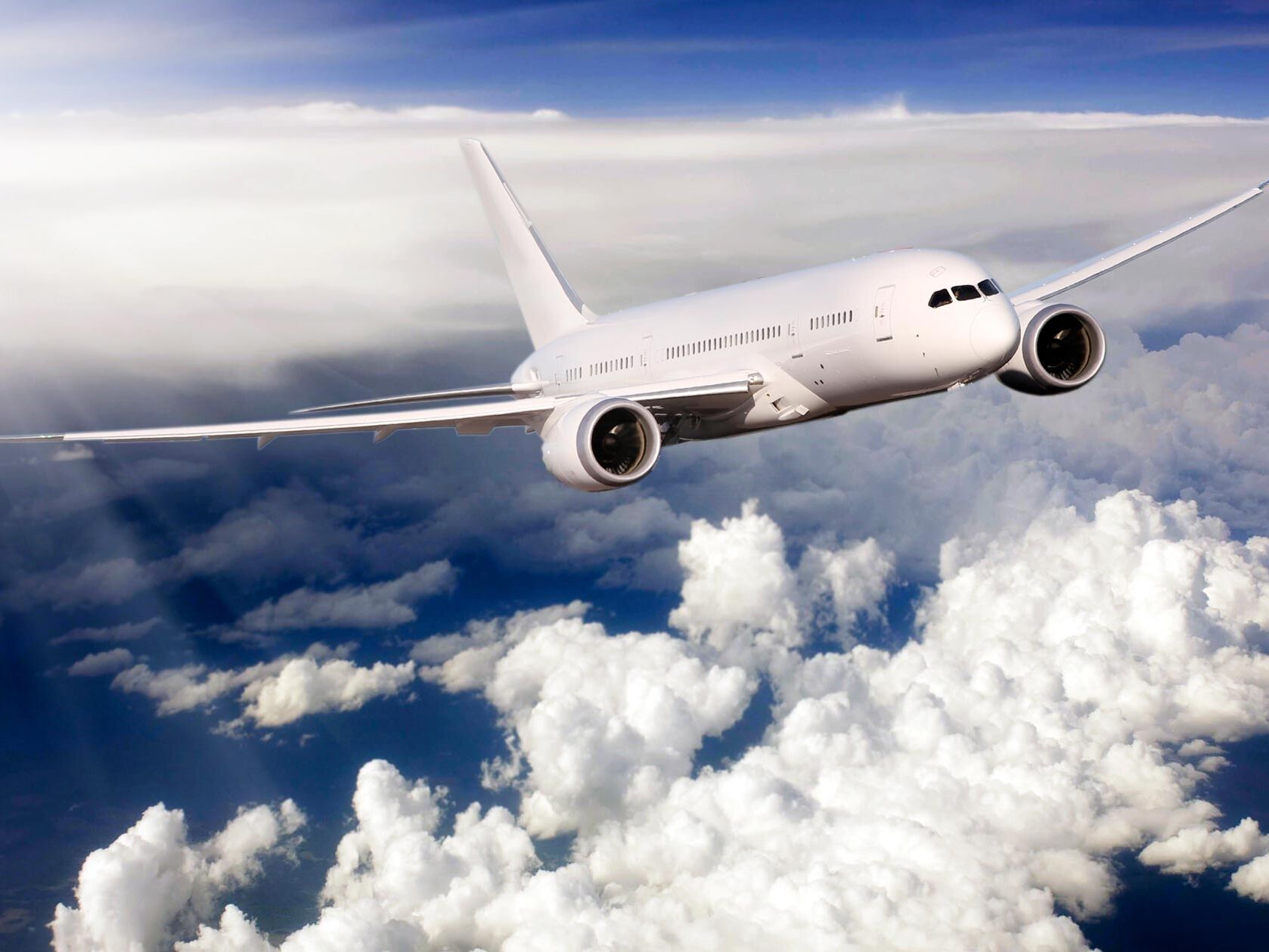 Photo of a passenger jet flying above the clouds.